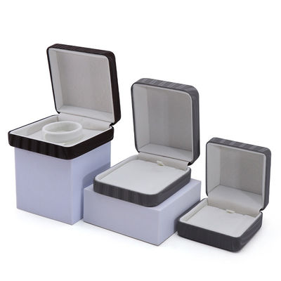 Caja de embalaje de joyas de cuero falso de granos de alta gama con ornamento de barra de oro