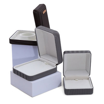 Caja de embalaje de joyas de cuero falso de granos de alta gama con ornamento de barra de oro
